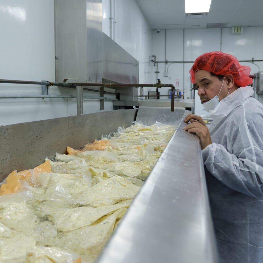 Worker inspecting packaged food in processing tank